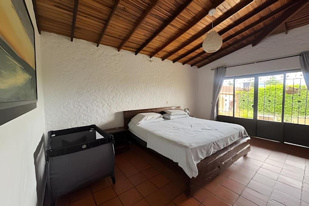 a bedroom with a bed and a large window at Exclusiva cabaña el lago- Naturaleza in Chinácota
