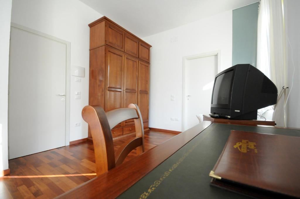 a living room with a table and a television at Guest House Domus Urbino in Urbino