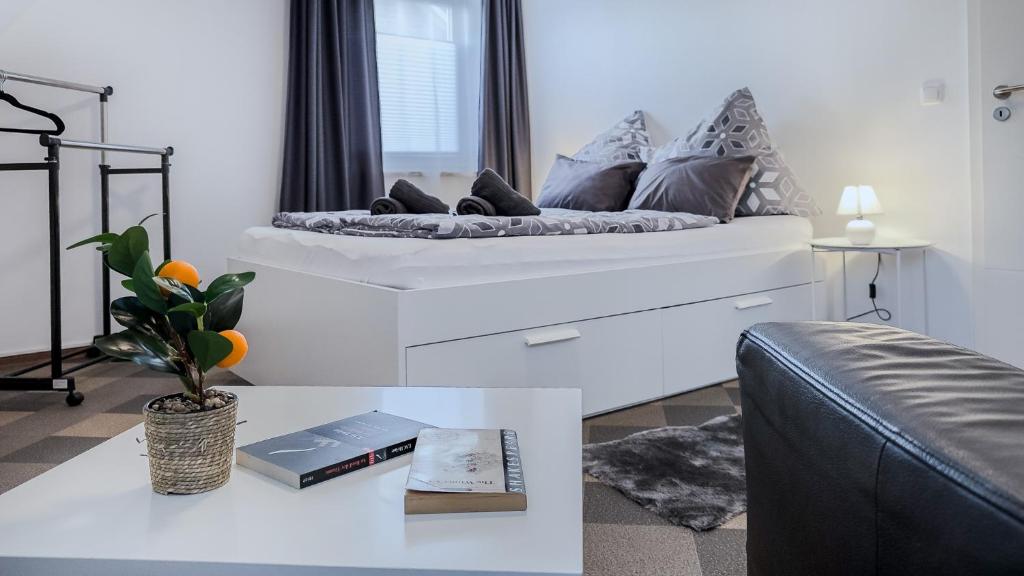 a white bedroom with a bed and a couch at Kassel - Gemütliches DG Apartment in Fuldatal mit Parkplatz & Wlan - OneN8 in Fuldatal