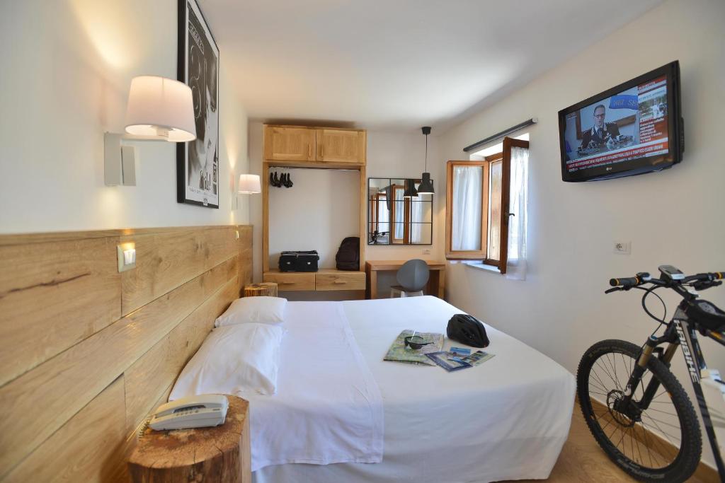 Un dormitorio con una cama y una bicicleta. en Albergo Les Dependances en Norcia