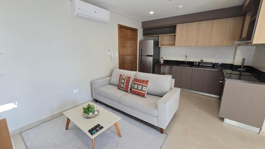 a living room with a white couch and a table at Departamento a estrenar en Mburucuya in Asuncion