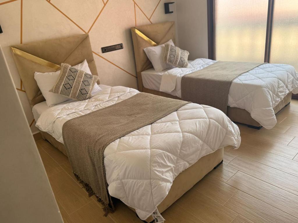 two beds in a hotel room with at Mount&Mer in Sidi Ifni