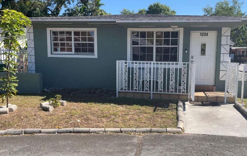 a small house with a white door and a porch at Simplicity1 in North Miami Beach