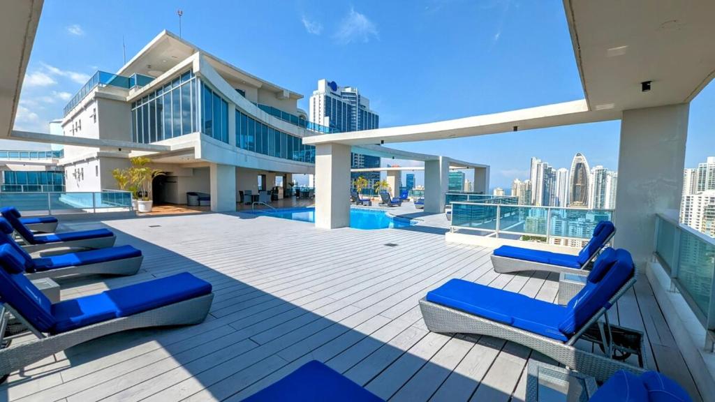 Una terraza con tumbonas azules en la parte superior de un edificio. en YC 2307 l Av Balboa 2 BDR bay view, en Panamá