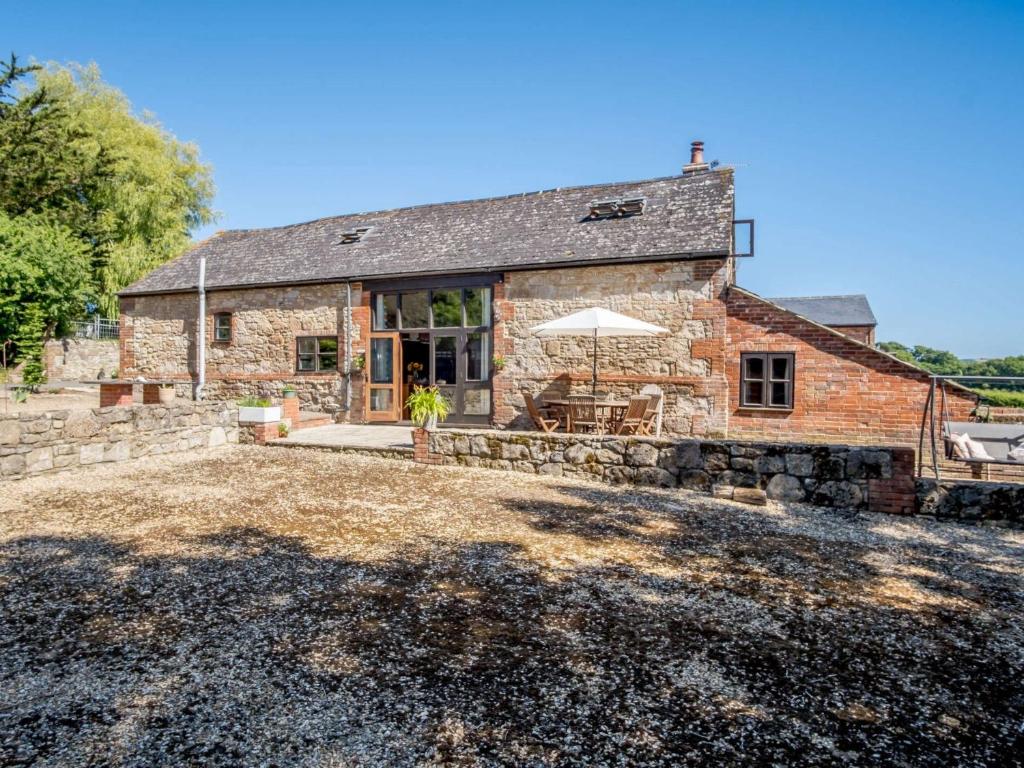 a stone house with an umbrella and a patio at 4 Bed in Cowes 88913 in Porchfield