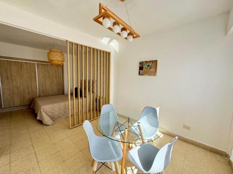 a room with a glass table and chairs and a bed at Depto zona centro MDP in Mar del Plata