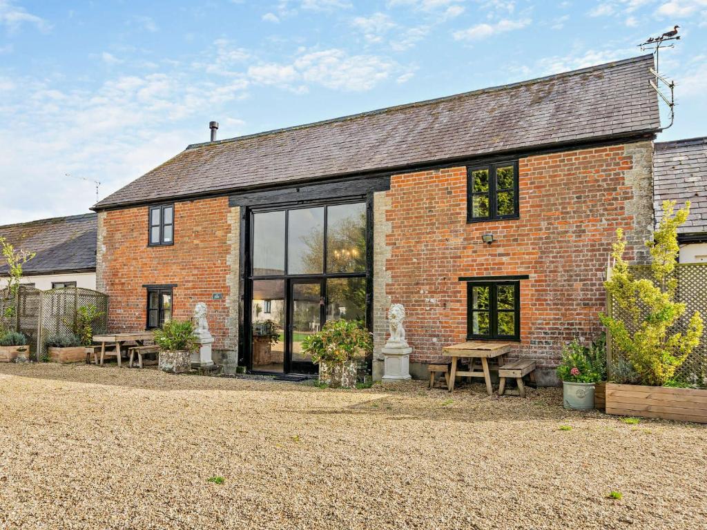 a brick house with glass windows and a picnic table at 3 Bed in Shaftesbury 95685 in Sedghill