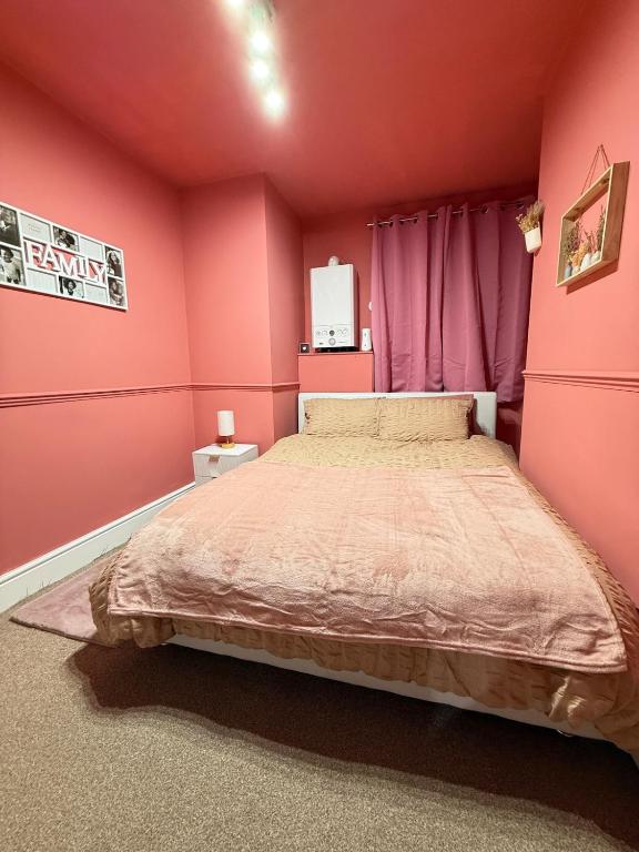 a bedroom with a large bed with pink walls at The Rosy Retreat By Station in Cambridge