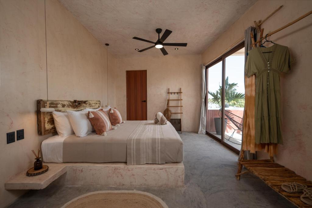 a bedroom with a large bed and a large window at Casa Coyote Holbox in Holbox Island
