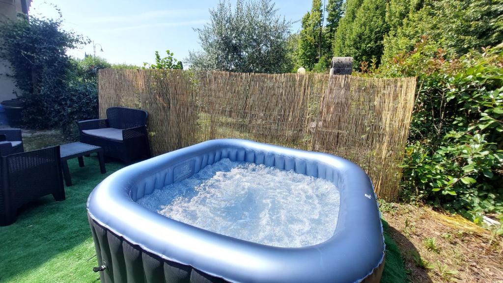 a blue tub filled with water in a backyard at jacuzzi e giardino privato - 10 minuti lago maggiore - con parcheggio - vicino malpensa MXP in Somma Lombardo
