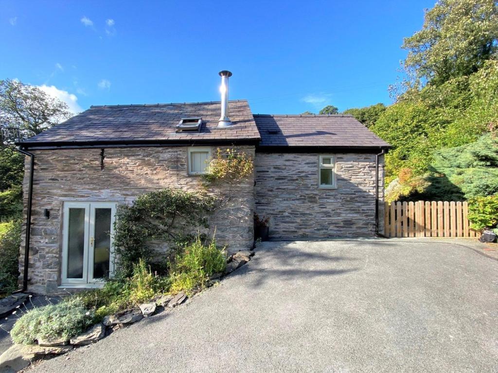 a stone house with a driveway in front of it at 1 Bed in Llangollen 78471 in Glyn-Ceiriog