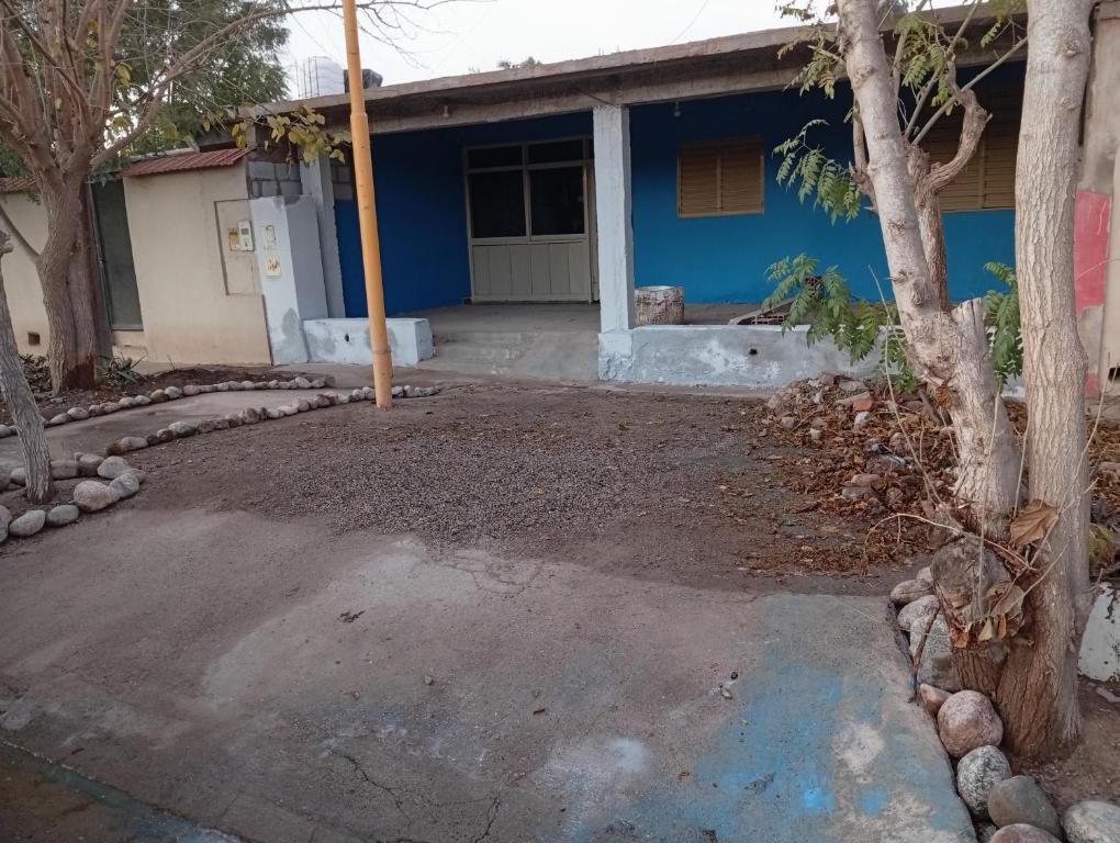 a blue house with a tree in front of it at Casa Alojamiento TELAR DE SUEÑOS in Belén