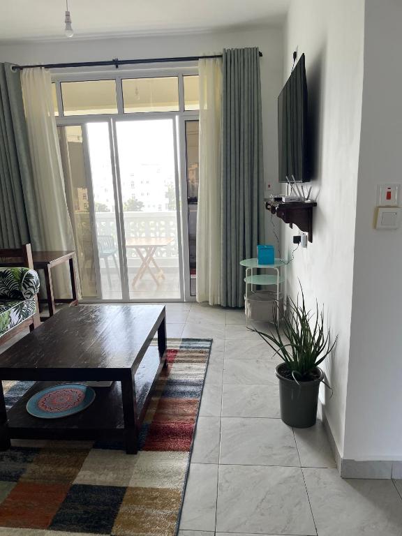 a living room with a coffee table and a sliding glass door at Coral Whispers in Malindi