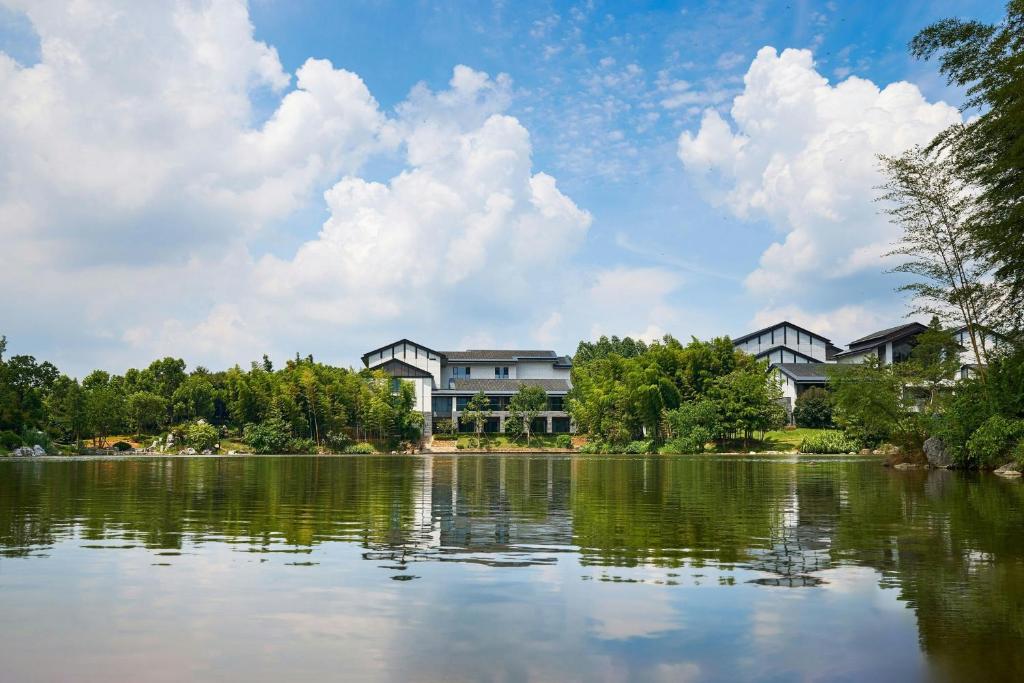- une vue sur un lac avec des maisons en arrière-plan dans l'établissement Grand New Century Resort, Changxing, A Tribute Portfolio Resort, à Guzhu