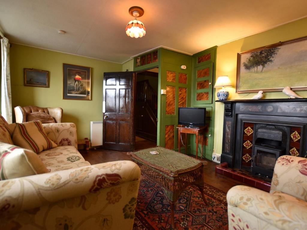 a living room with two couches and a fireplace at 3 Bed in Polruan PC032 in Fowey