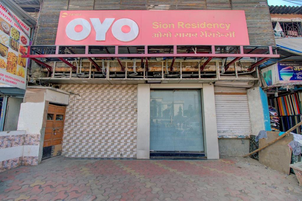 a building with a sign on the side of it at Hotel O Sion Residency in Mumbai