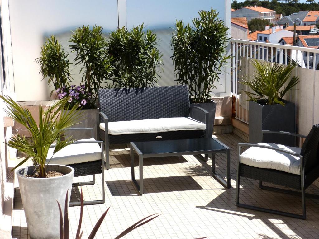 d'un balcon avec des chaises, une table et des plantes en pot. dans l'établissement T2 avec Wifi, grande terrasse exposée sud, à 500m de la plage - FR-1-92-924, à Les Sables-dʼOlonne