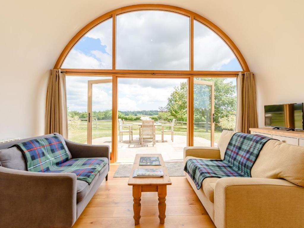 a living room with two couches and a large window at 1 Bed in Rolvenden 76565 in Rolvenden