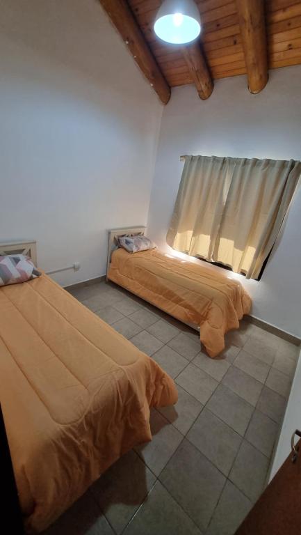 two beds in a room with a window at La Casita El Martillo in Concordia