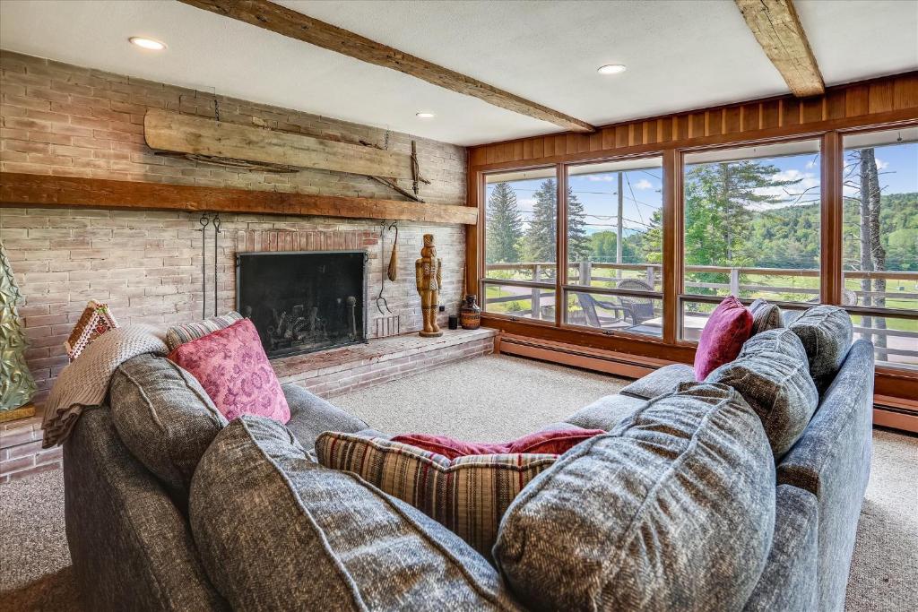 a living room with a couch and a fireplace at Mountain Haus in Stowe Fork