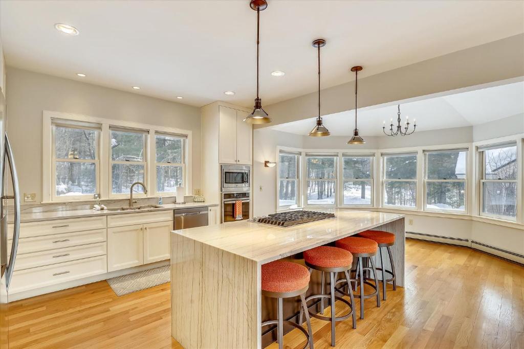 a kitchen with a large island with bar stools at The Eagle's Nest at Stowe in Stowe