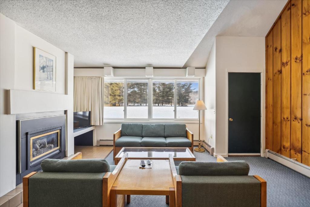 Una sala de estar con dos sofás y una chimenea. en Village Green 8D, en Stowe