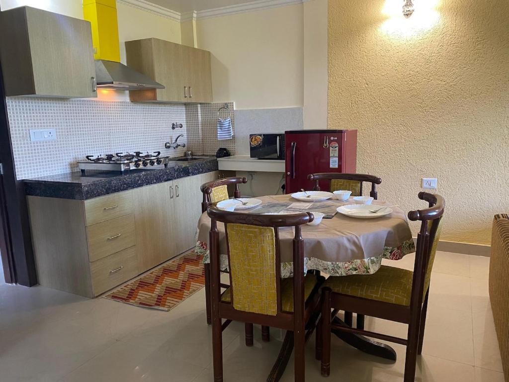 a kitchen with a table with chairs and a stove at The Alpine Ramgarh in Rāmgarh