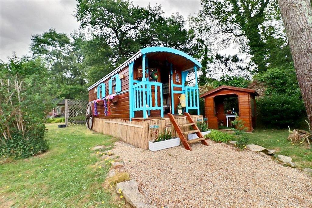 a small house is sitting in a yard at Roulotte la comtesse gitane in Plescop