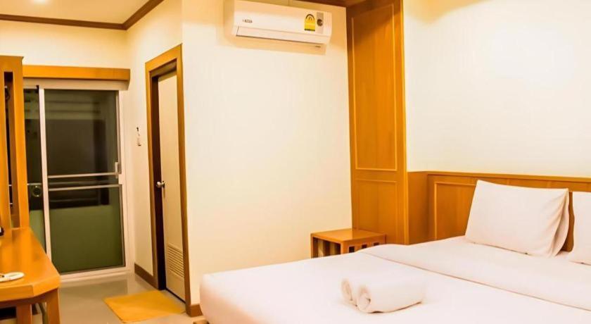 ein Schlafzimmer mit einem weißen Bett und einem Fenster in der Unterkunft Loei Residence in Ban Tha Phae