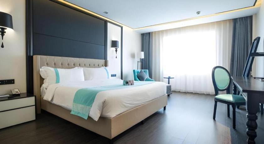 a large bedroom with a large bed and a desk at Xana Hotelle Jinan Daminghu North Gate in Jinan