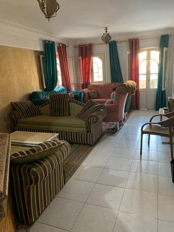 a living room with couches and chairs and windows at ELzohor Resort in Alexandria