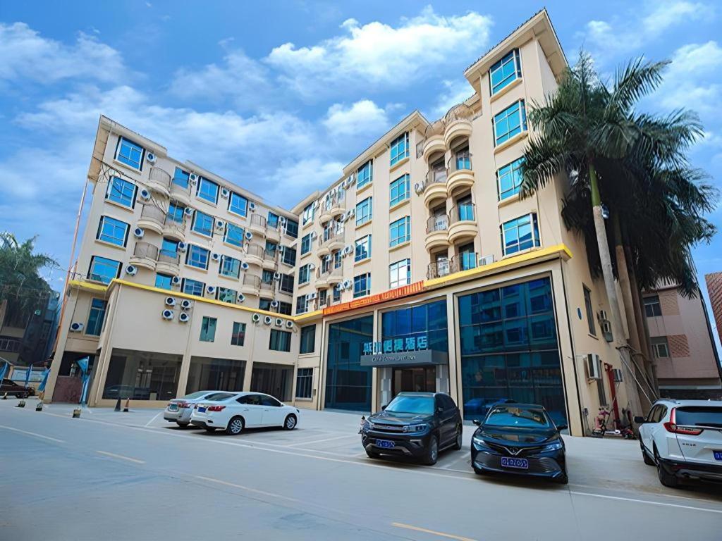 a large building with cars parked in a parking lot at City Comfort Inn Yangjiang High-tech Zone Pinggang in Yangjiang