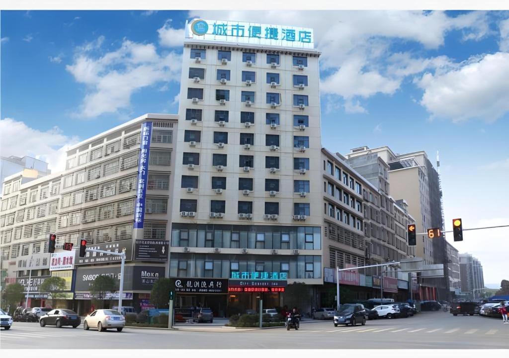un edificio blanco alto con un cartel encima en City Comfort Inn Shaoyang Wugang, en Wugang