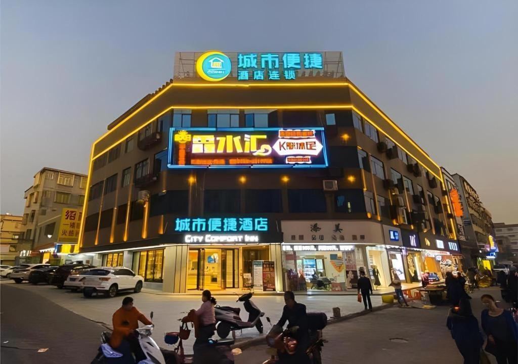 een groep mensen die voor een gebouw zitten bij City Comfort Inn Zhaoqing Sihui Nanjiang Industrial Park in Xiahuangtang