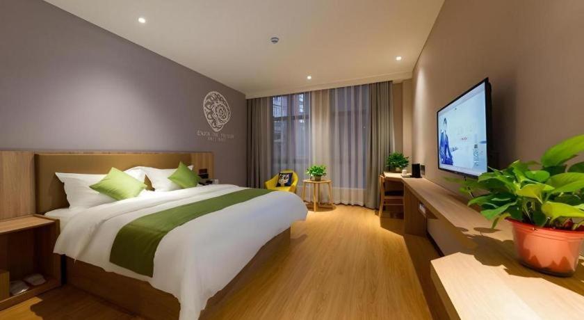 a bedroom with a large bed and a flat screen tv at Shell Hotel Anhui Huaibei Suixi County Economic Development Zone in Suixi