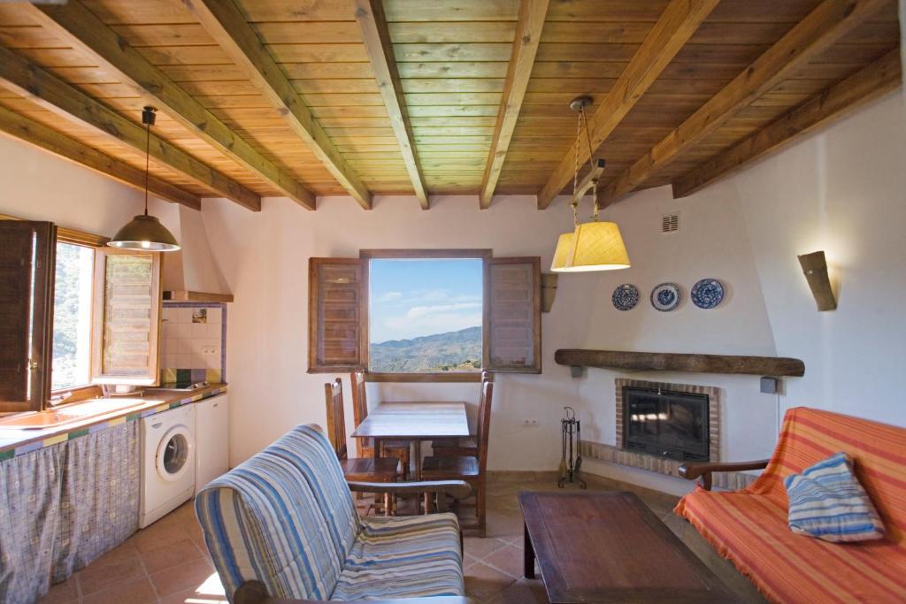 a living room with a table and a fireplace at Apartamento El Mirador Rocabella in El Chorro