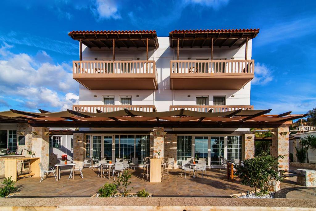 a building with a patio with tables and chairs at Pal Beach in Palaiochora