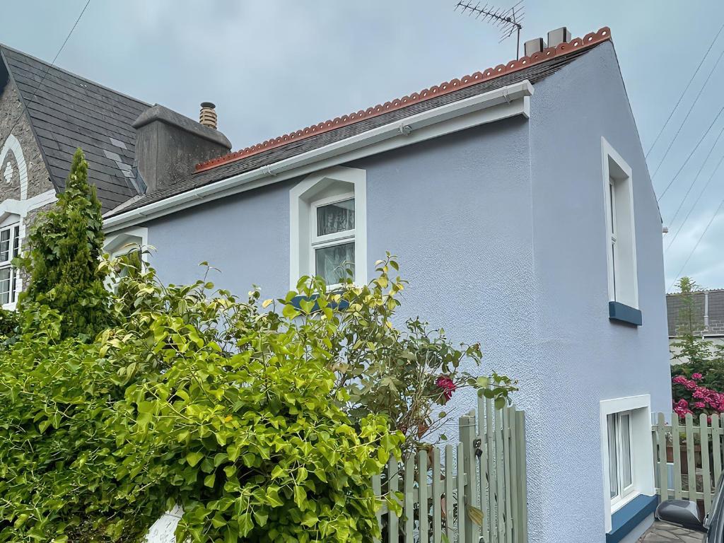 a white house with a white fence at Little Acre in Torquay