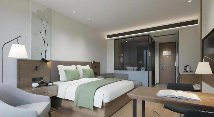 une chambre avec un grand lit blanc et un bureau dans l'établissement GreenTree Inn Express Jinan Zhangqiu Districty Ancinet Town Longquan Road, à Zhangqiu