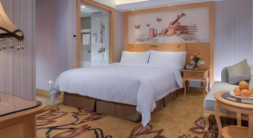 une chambre avec un grand lit dans une chambre d'hôtel dans l'établissement Vienna Hotel Shenzhen Qinghu Metro Station, à Tiantangwei