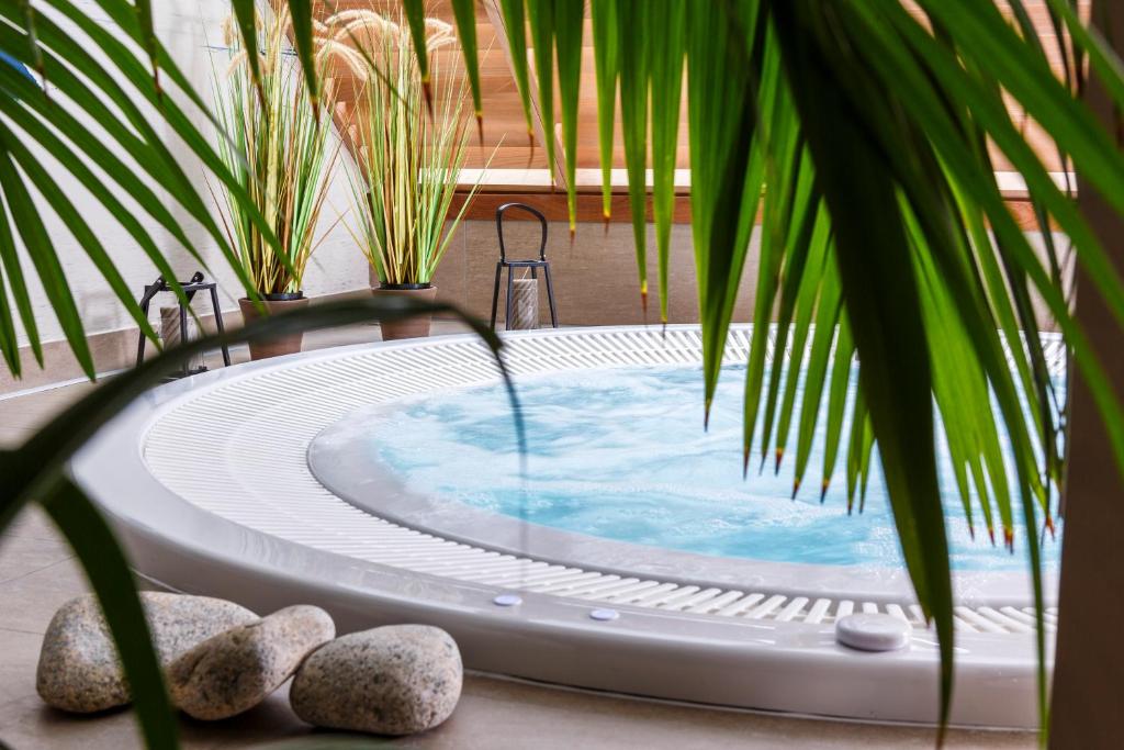 a jacuzzi tub in a courtyard with plants at Best Western Les Bains Hotel et SPA in Perros-Guirec