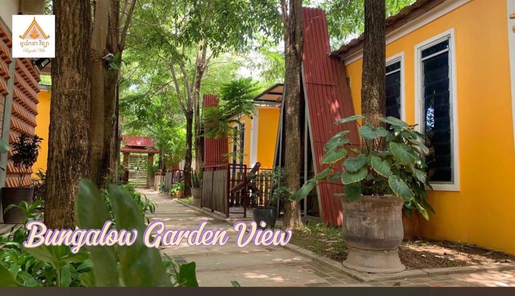 a house with a plant in a pot next to a street at Dream Village in Phum Pobos