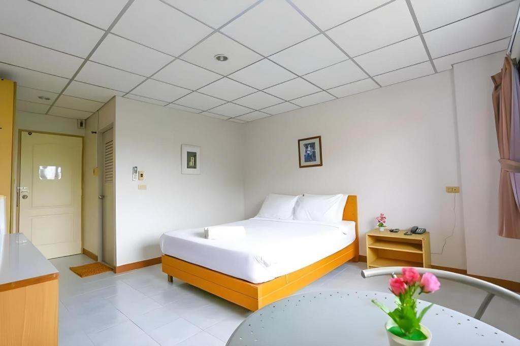 ein Schlafzimmer mit einem großen Bett und einem Tisch in der Unterkunft Central Place Hotel in Ban Thai Wat Khot