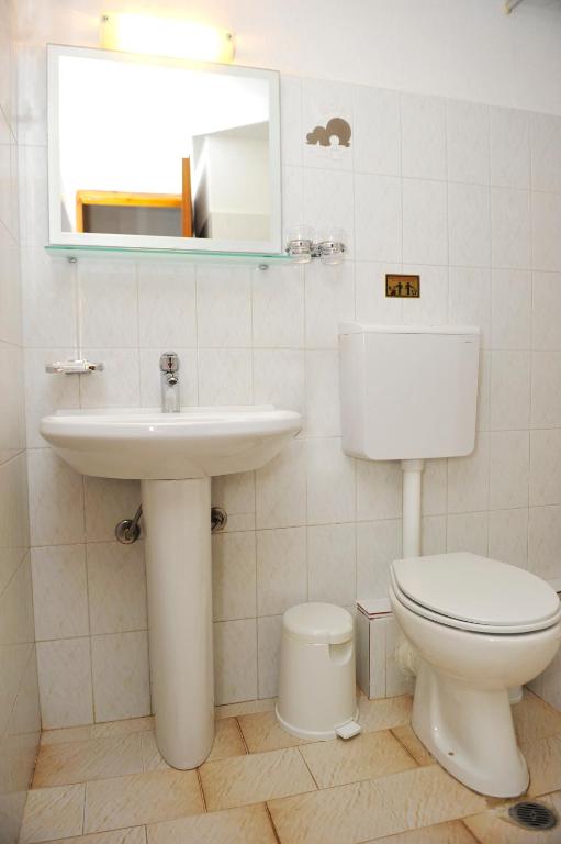 a bathroom with a toilet and a sink and a mirror at Villa Anna Maria in Agia Paraskevi