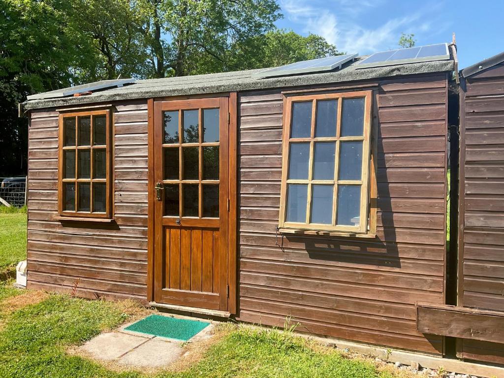 a wooden shed with a door and windows at Sweet Briar - Uk49797 in Brecon