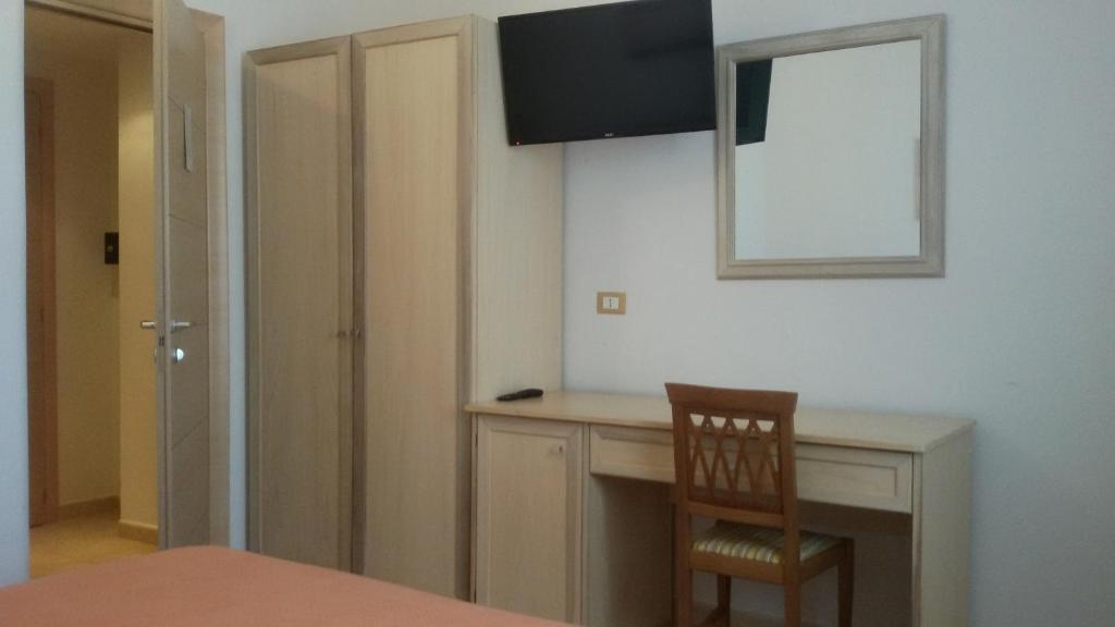 a room with a desk with a chair and a mirror at Hotel Corallo in Torre Santa Sabina