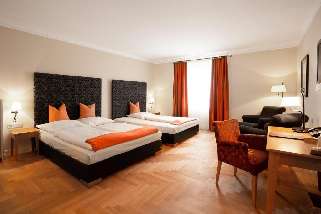 a hotel room with two beds and a desk at Hotel Villa Florentina in Frankfurt