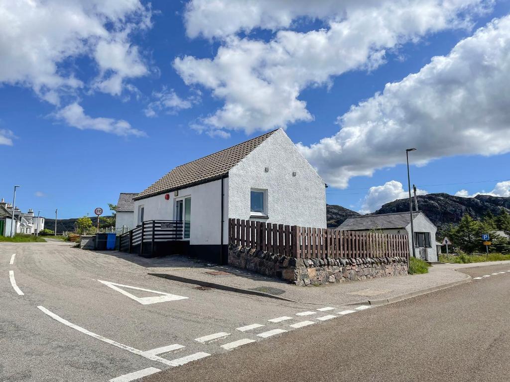 a white building on the side of a road at The Old Surgery in Kinlochbervie