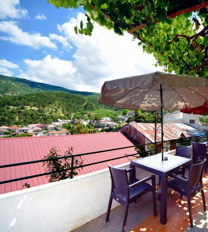 a table and chairs with an umbrella on a roof at Christys Palace Hotel in Pedoulas