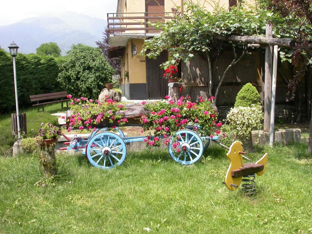 a garden with a horse drawn cart with flowers at Agriturismo La Bordiga in Paesana